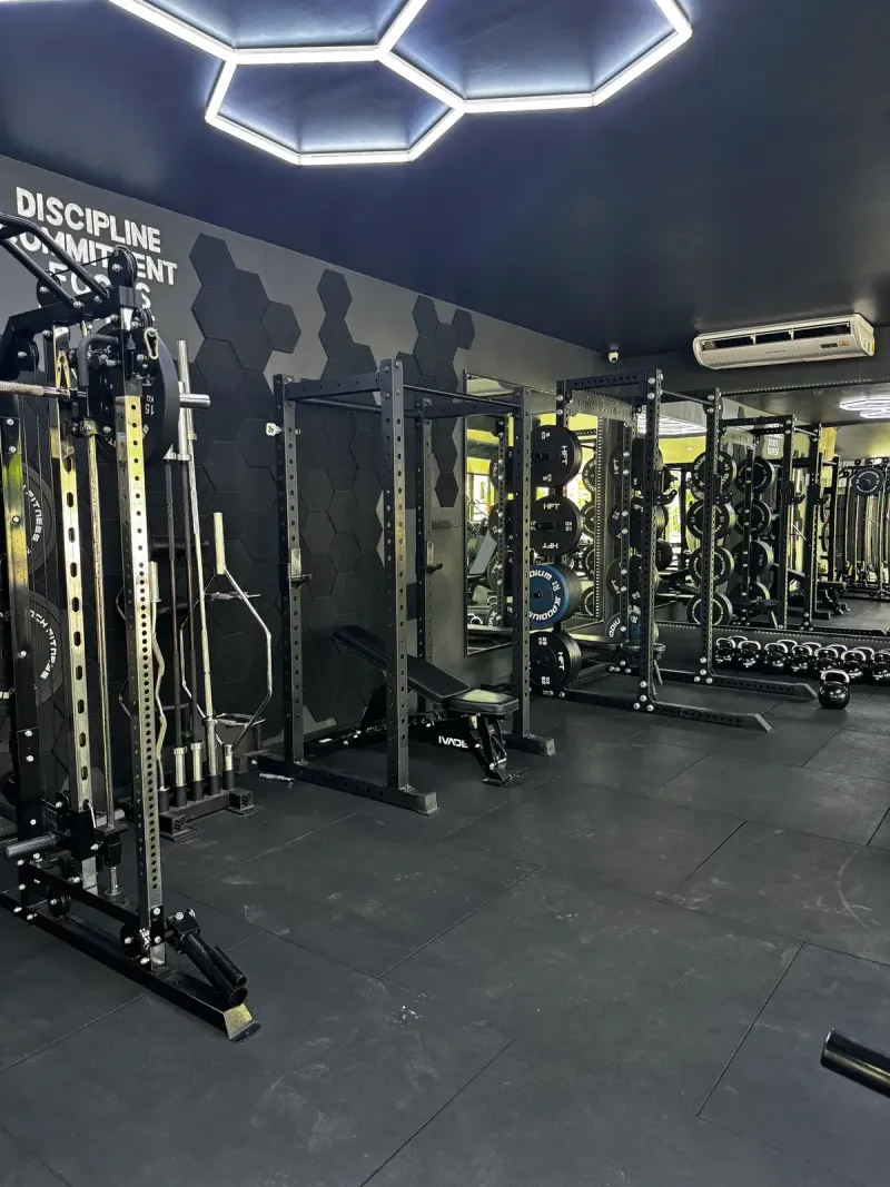A row of squat racks and cable stations in the air-conditioned strength gym