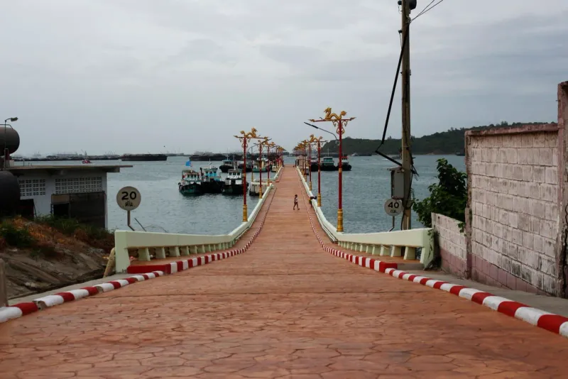 Pier leading out to fishing boats on calm water, comparable to Bang Rak Pier on Koh Samui