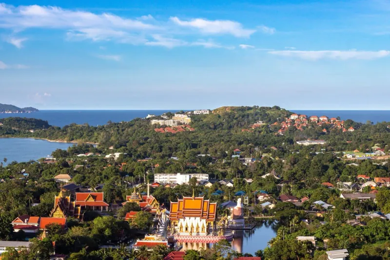 High-angle view of a coastal town and temple, illustrating the harbor-town setting of a Koh Samui cruise stop