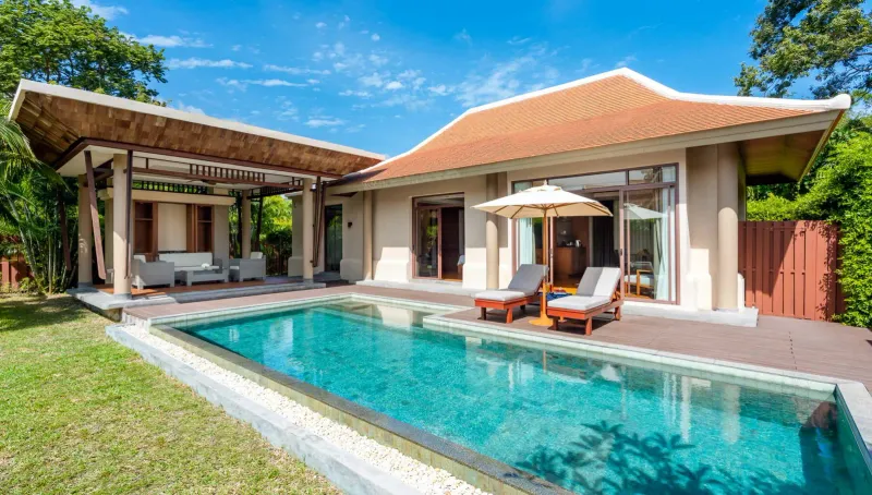 Private pool villa with a terracotta roof, sun loungers and lawn at Santiburi Koh Samui