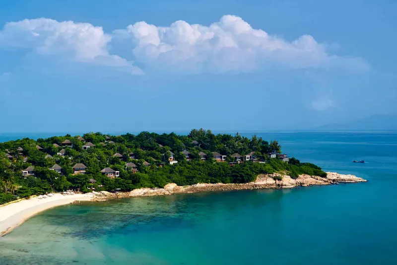 Aerial view of the Samrong Bay headland at Six Senses Samui with villas in the forest and turquoise water