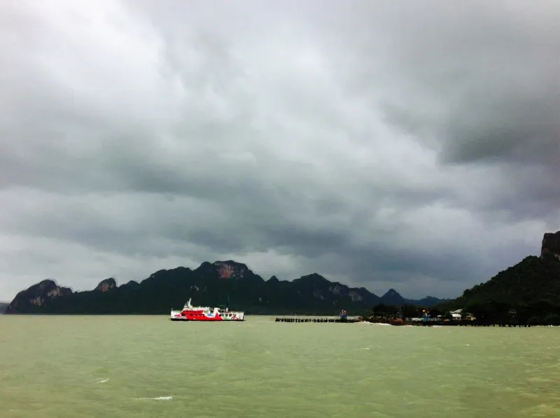 曇り空の下、タイ湾の波立つ海を進むフェリー