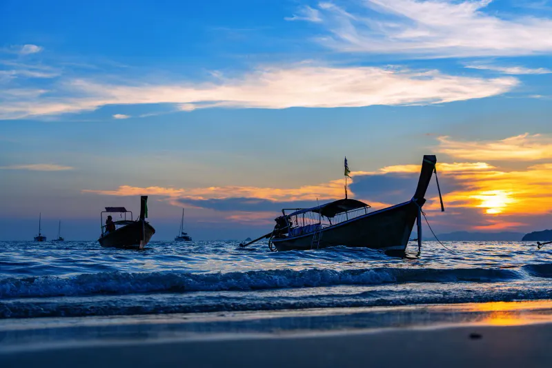 Longtail boats silhouetted at sunset off Koh Samui's west coast