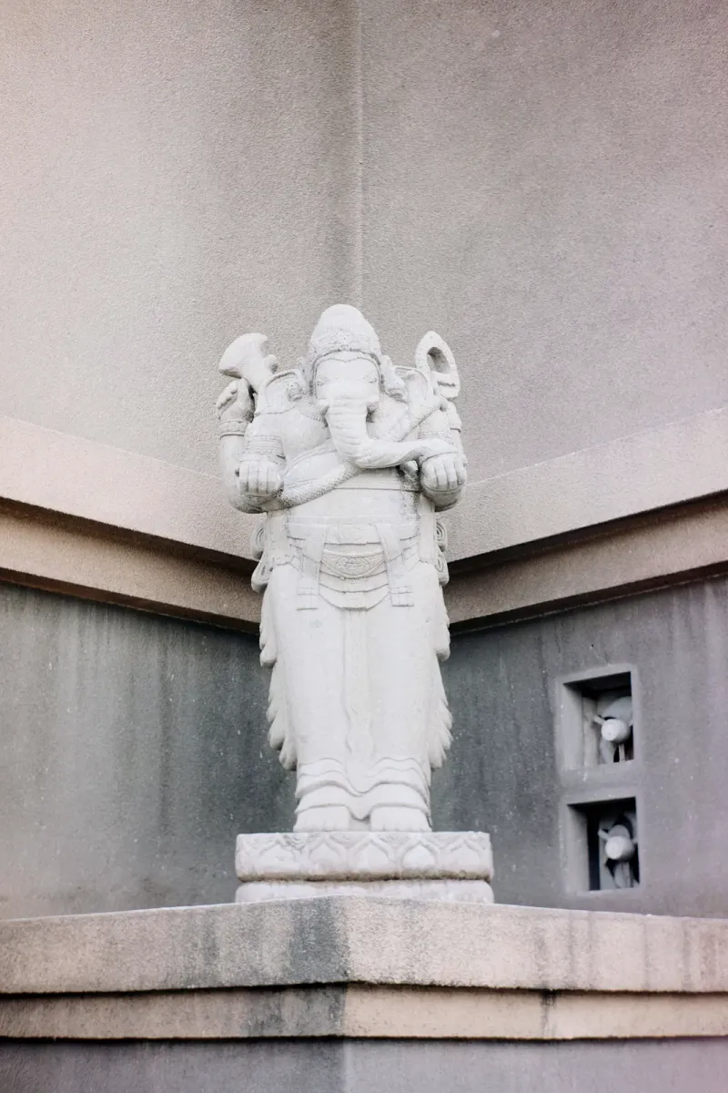 Weathered stone statue of the elephant-headed deity Ganesha, occasionally found at Thai temple grounds