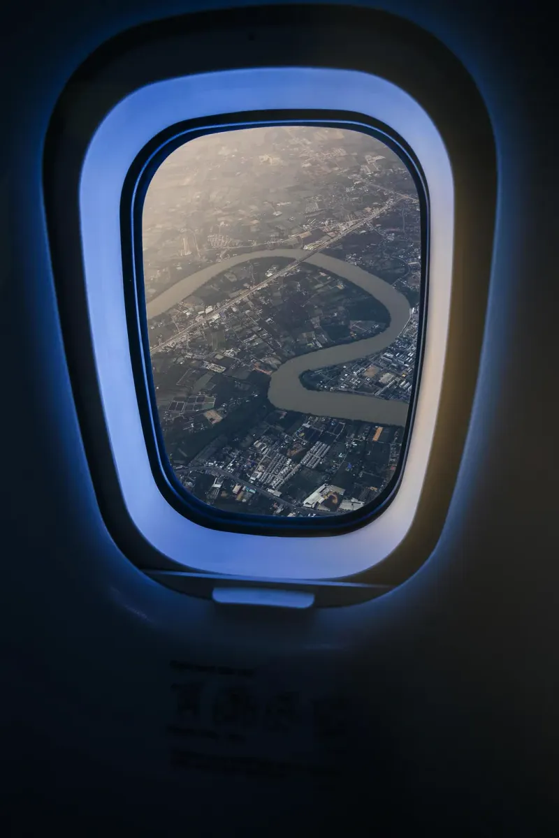 タイ上空の旅客機の窓から見た、農地と郊外の間を曲がりくねって流れる川