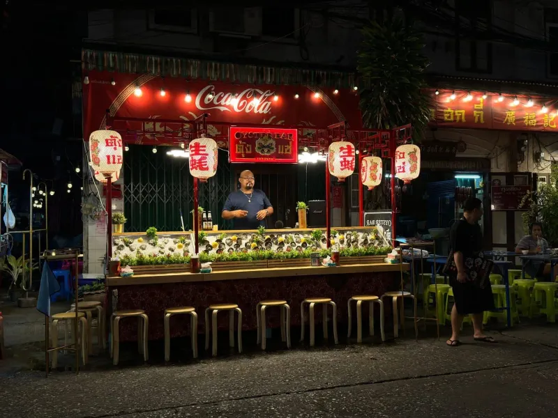 Illuminated food stall with hanging lanterns at a Koh Samui night market street