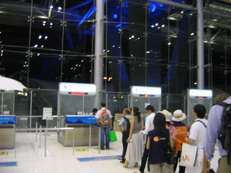 Passengers at a passport and immigration control counter at a Thailand international airport