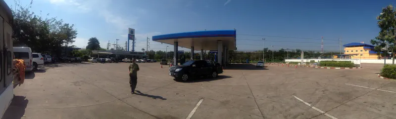 Roadside petrol station forecourt with canopy and a pickup truck in Thailand