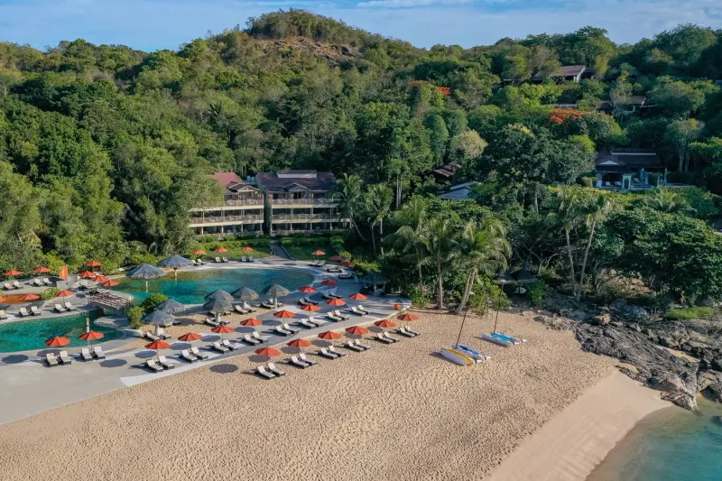 Close aerial of the beach with sail catamarans lined up on the sand