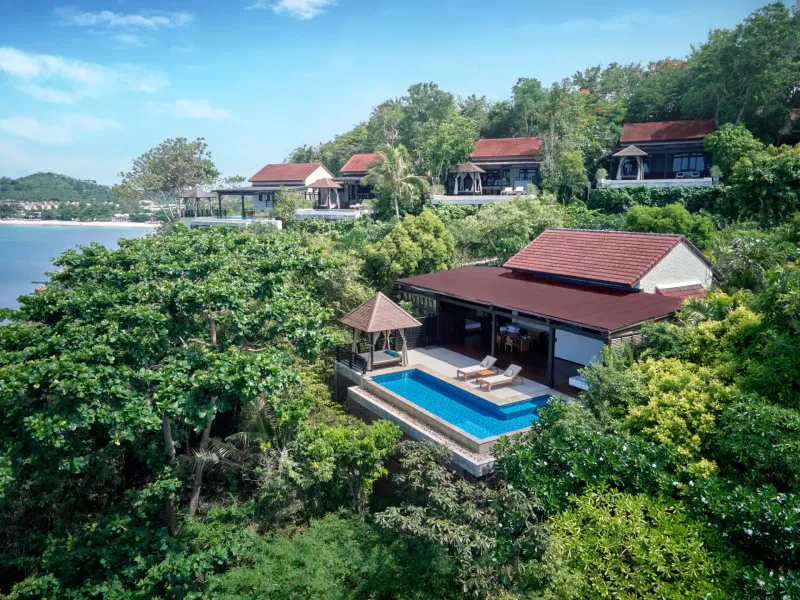 Hillside villas with private pools set among the trees above the bay