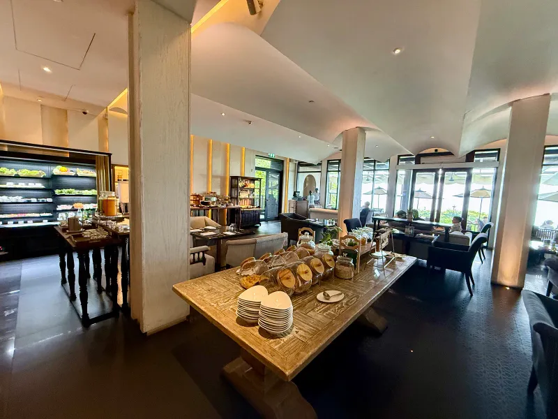 Breakfast buffet at Vana Belle with pastries and a long serving table beside large windows