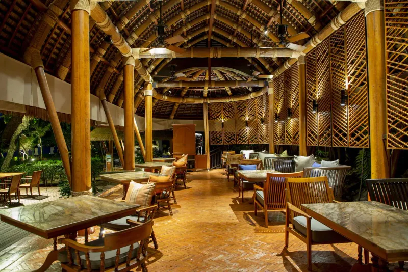 Open-air timber restaurant pavilion with a high thatched roof at Vana Belle Koh Samui
