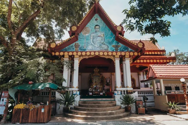 Wat Khunaram's ordination hall facade with a mosaic mural of the monk above the entrance